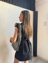 Chaleco corto negro con solapas, doble botonadura y corte sastrero. Sin mangas.