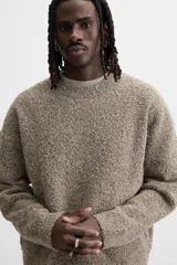 Sweater color arena con textura bouclé, cuello redondo, manga larga y terminaciones en rib.