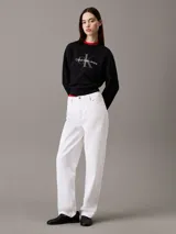 Buzo negro de felpa con cuello redondo y logo Calvin Klein Jeans estampado en el pecho. Tiene ribetes rojos en el cuello y en el ruedo.