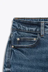 Jeans de tiro alto color celeste, corte mom fit, con cinco bolsillos y cierre frontal con cremallera y botón.