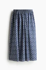 Pollera larga de algodón con estampado floral blanco sobre fondo azul, corte holgado, tiro alto y cintura elástica. Forrada.