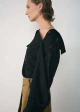 Camisa negra de lyocell y poliéster con cuello de solapa, bolsillo de solapa con botón en la parte delantera, diseño asimétrico y recto, cierre de botón en el cuello y cuello asimétrico.