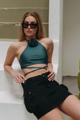 Minifalda de jean azul con corte en A y bolsillos tipo cargo con solapa y botón. Tiene un chaleco haciendo juego con cierre de botones.