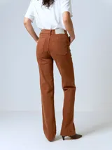 Pantalón jean color marrón, de tiro alto, corte recto y levemente acampanado. Presenta bolsillos delanteros y costuras visibles.