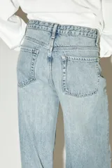 Pantalón de jean celeste de corte wide leg, tiro alto y largo hasta el tobillo.