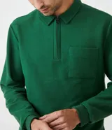 Buzo verde de algodón para hombre, modelo comfort con cuello polo con cremallera, mangas largas, bolsillo frontal y puños ajustados.