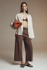Pantalón culotte color verde oliva, de tiro medio y pierna ancha. Incluye cinturón ajustable con hebilla metálica y cierre lateral con cremallera oculta.