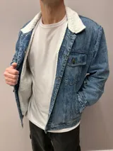 Chaqueta de jean azul con cuello y forro de corderito blanco.