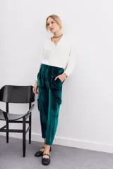 Pantalón babucha verde esmeralda de terciopelo con elástico en la botamanga, bolsillos plaqué en el frente con remaches metálicos y bolsillos cargo en las piernas.