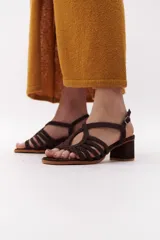 Sandalia de mujer color terracota/rojo oscuro, con taco ancho y tiras trenzadas que cubren el empeine. Posee tira ajustable con hebilla en el tobillo.