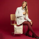Bandolera color beige de símil cuero con dos bolsillos frontales con cierre, un bolsillo trasero y tres bolsillos internos. Incluye correa larga regulable.