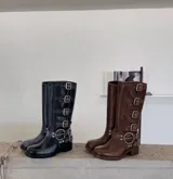 Botas de caña alta color marrón con múltiples correas con hebillas plateadas y suela track.