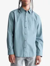 Camisa celeste de manga larga con cuello clásico, cierre frontal con botones, bolsillo de parche en el pecho y logo de Calvin Klein bordado en el bolsillo.