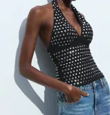Top negro con cuello halter y espalda descubierta, con apliques de lentejuelas plateadas.