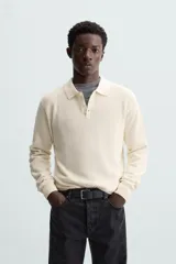 Polo marrón de corte relaxed fit, tejido en punto de algodón. Tiene cuello solapa con cierre frontal de botonadura, manga larga y acabados en rib.