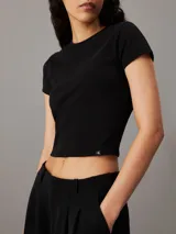 Remera negra de algodón, corte slim cropped, cuello redondo y mangas cortas.