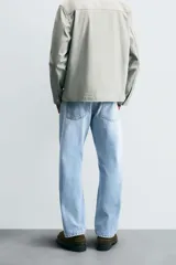 Pantalón de jean celeste de corte recto, con cinco bolsillos, efecto lavado y cierre frontal con botones.