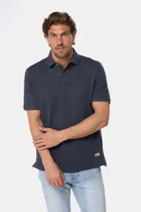 Chomba azul con textura de líneas horizontales en relieve, cuello clásico y tapeta con dos botones.