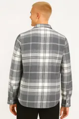 Camisa manga larga gris a cuadros blancos, con cuello clásico, cierre con botones y dos bolsillos con solapa abotonada en el pecho.