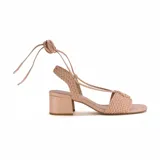 Sandalia color rosa con tiras trenzadas y cierre con cordones.