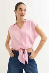Camisa celeste con cuello, abotonada al frente y mangas cortas.