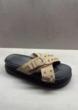 Sandalias con plataforma color beige, con dos tiras cruzadas con tachas plateadas y hebilla decorativa.