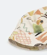 Sombrero tipo bucket de algodón con estampado de figuras abstractas y animales en tonos pastel.