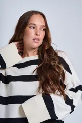 Sweater tejido a rayas horizontales anchas color crudo y negro, con cuello redondo y mangas largas.