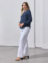 Blusa blanca de manga larga con cuello redondo y detalle de broderie en el canesú.