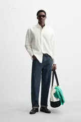 Camisa azul marino de algodón con textura jacquard, corte relaxed fit, cuello solapa, manga larga con puños abotonados y cierre frontal con botones.