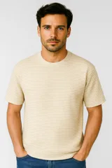 Remera de poliéster color beige con rayas horizontales, corte holgado y cuello redondo.