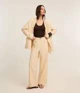Pantalón wide leg de cintura alta color beige, confeccionado con lino y viscosa. Incluye cinturón elástico con hebilla metalizada.