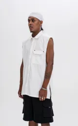Camisa blanca sin mangas de calce oversize con doble bolsillo y detalle de remaches en el frente, confeccionada en tejido twill de alta calidad.
