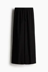 Pantalón negro de punto con textura, corte holgado, tiro alto, piernas rectas, elástico revestido en la cintura y cordón para ajustar.