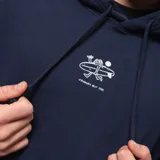 Canguro azul marino con capucha y bolsillo tipo canguro. Estampado pequeño en el pecho con diseño abstracto en blanco.