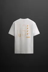Camiseta blanca de algodón con corte relaxed fit, cuello redondo y manga corta. Estampado en el frente con un logo pequeño y en la espalda con un diseño de tablas de surf y texto.