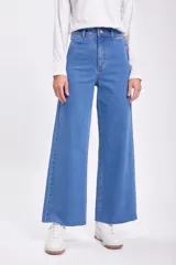 Pantalón jean ancho de tiro alto, color azul medio, con terminación desflecada en el ruedo.