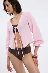 Camisa blanca de mangas largas con puños elásticos y escote en V con lazo.