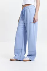 Pantalón de felpa celeste con cintura elastizada ajustable y bolsillos laterales.