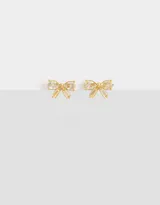 Par de aros pasantes dorados con forma de moño y piedras de cubic zirconia.