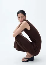 Vestido midi marrón sin mangas, con cuello alto y diseño entallado con drapeado lateral.