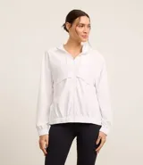 Campera deportiva femenina cortaviento, modelo alargada con capucha, cierre frontal con cremallera y saquito para guardar.