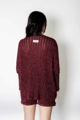 Conjunto de sweater y short de punto color borgoña con lurex. El sweater es de corte holgado con cuello en V y mangas largas. El short es de corte holgado con cintura elástica.