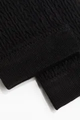 Calzas negras sin pie en punto trenzado suave con cintura estándar elástica y bajos acanalados.