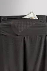Shorts deportivos marrones de tejido técnico ligero y elástico con diferentes estructuras. Tiene forro interior, cintura elástica ajustable con cordón, bolsillos frontales, bolsillo trasero con cierre, aberturas laterales y logo estampado en la pierna.
