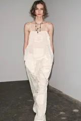 Top blanco de algodón con tirantes finos y bordados combinados a tono.