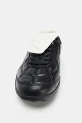 Zapato deportivo estilo running color negro con detalle de acolchado en el cuerpo, suela con relieve, cierre mediante cordones y lengüeta.