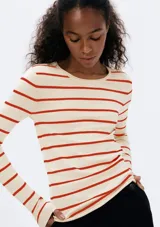 Remera de punto color crema con rayas horizontales negras, de mangas largas y cuello redondo.