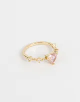Anillo dorado con dije de corazón rosa y strass blancos.