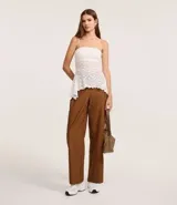 Pantalón recto color marrón confeccionado en cupro, con trabillas en la cintura, cierre tradicional y superposición lateral.